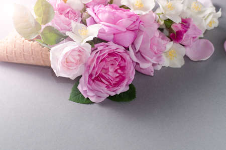 Fresh spring roses in waffle cone. Beautiful romantic background in flat lay style.の写真素材