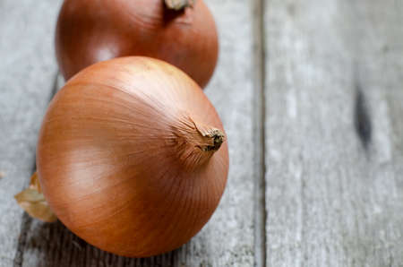 Ripe golden onion on a vintage rustic wooden table.の写真素材