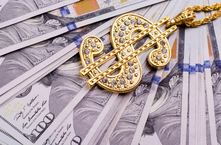 Gold Dollar Sign Necklace on a United States Dollars Banknotes. Financial business background.