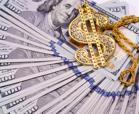 Gold Dollar Sign Necklace on a United States Dollars Banknotes.