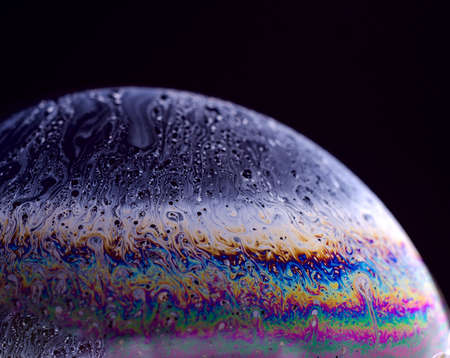 Abstract macro of soap bubble. Close up surface of soap bubble seems like planet in space. Bright creative background.の写真素材