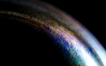 Abstract macro of soap bubble. Close up surface of soap bubble seems like planet in space. Bright creative background.の写真素材
