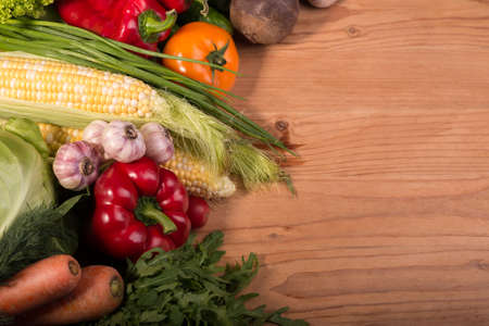 Assortment of fresh raw vegetables on a wooden table. Healthy organic local food. Top view background with empty space.の写真素材