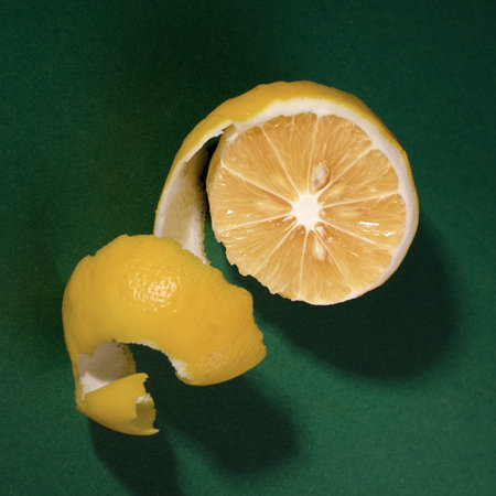 Fresh juicy lemon with shadow on a green background. Minimalist poster
