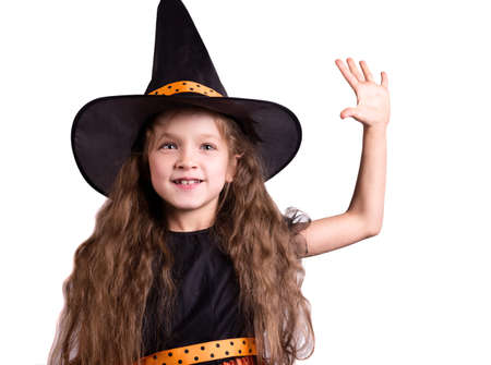 Happy laughing little girl wearing a witch carnival costume. Child girl Halloween kid against a white background.の写真素材