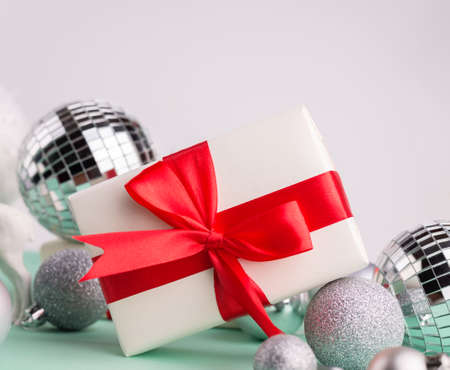 Merry Christmas and Happy New Year greeting card Frame, Banner with Gift Boxes with Red Bow, Festive Decorations, Big Snowballs on a Turquoise Background.の写真素材