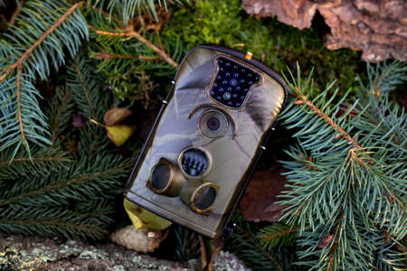 Advertising photo of Trap or Hunting Camera With Infrared Light and a motion detector on the Forest Floorの写真素材