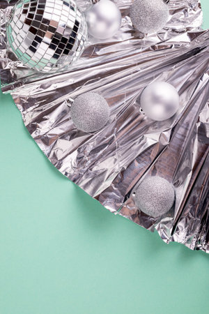 Happy New Year and Merry Christmas Festive background with silver balls on a shiny foil. With space...