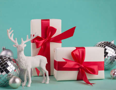Merry Christmas and Happy New Year greeting card Frame, Banner with Gift Boxes with Red Bow, Festive Decorations, Big Snowballs, and on a Turquoise Background.の写真素材