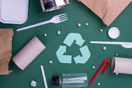 Reuse reduce recycle flat lay concept with plastic, paper, and polyethylene waste. Template image with recycling symbol.の写真素材