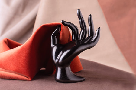 Black Plastic Mannequins Hand Holding piece of velor fabric. Fabric texture backgroundの写真素材