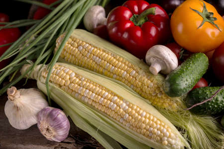 Dark moody still life of fresh vegetables on a wooden table. Healthy organic local food grocery background.の写真素材