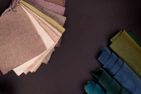 Collection of emerald velvet textile samples in green and blue colors and gunny textile against black. Fabric texture backgroundの写真素材