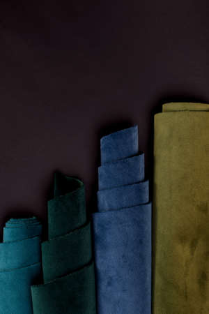 Collection of emerald velvet textile roles in green and blue colors against black. Fabric texture backgroundの写真素材