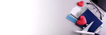 Romantic Airplane Travel planing banner with objects, documents, dollars, passports, boarding pass tickets, glasses, smartphone, and space for text.の写真素材