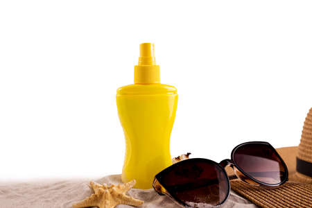 Sunscreen spray bottle and summer straw hat beach shoes and sunglasses against white copy space. Summer vacation banner concept.の写真素材