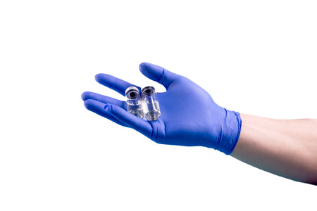 Vaccination  concept with doctors hands wearing protective gloves, holding bottle of liquid...