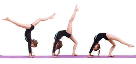 Cute child girl making Gymnastic exercises against white background.の写真素材
