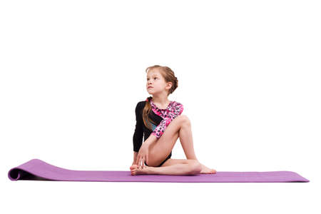 Cute child girl making Gymnastic exercises against white.の写真素材