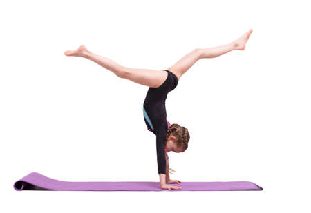 Cute child girl making Gymnastic exercises against white.の写真素材