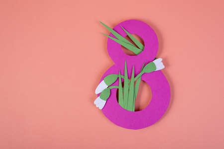 Paper art Eight number cut of pink against the pink background with paper cut snowdrops. 8 March, womens day background with empty space.の写真素材