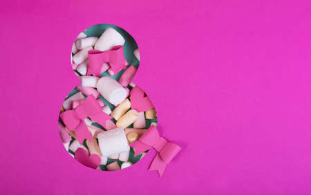 Paper art Eight number cut of bright pink paper against the turquoise background fulfilled by confetti, bows and one gif box.の写真素材