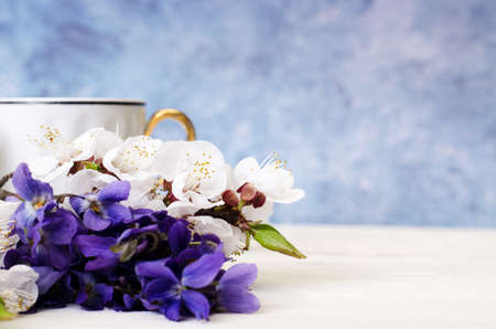 Bouquet with beautiful aromatic wild violets in a bowl. Composition with copy-space for greeting text.の写真素材