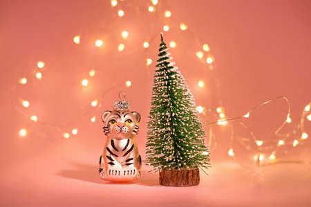 Tiger Christmas toy as the Symbol of year lunar chinese calendar on a greeting card. New Year Banner with Toy Christmas tree against.の写真素材