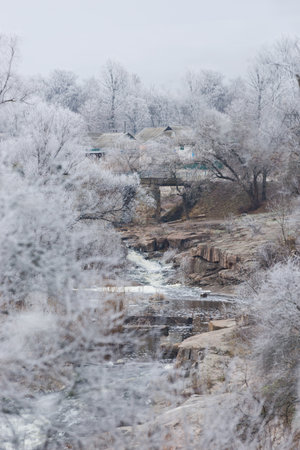Beautiful winter landscape with Old stone bridge across the Girskiy Tikych river running through frosted trees and rocks.の写真素材