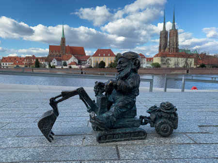 Poland, Wroclaw, April 16, 2022. The famous bronze miniature gnome digs on an excavator in front of the temples of Tumski Island.のeditorial素材