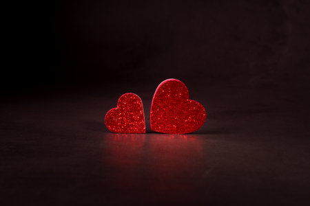 Valentines day concept banner with sparkling glitter hearts against abstract red background and the bokeh of garland with space for text.の写真素材