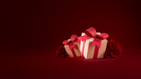 Paper art Valentines day concept banner with hand made gift box, paper cut ribbon, bow, and a lot of hearts on a red background with space for text.の写真素材