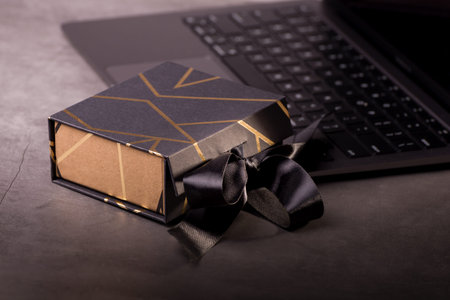 Black Gift Box Decorated With Golden Stripes on a laptop keyboard. Gifts for men. Good for Fathers...