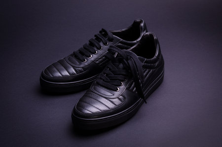 Fashionable genuine leather sneakers on a black background. Fashionable footwear.の写真素材