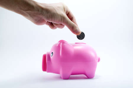 hand putting coin into piggy bankの写真素材