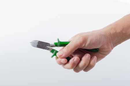 male hand holding nippers on white backgroundの写真素材