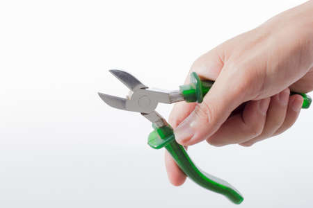 male hand holding nippers on white backgroundの写真素材