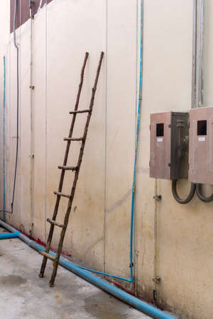 wooden ladder on wall near  breaker boxの写真素材