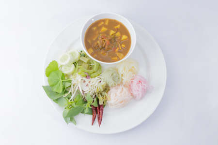 rice noodles rainbow in fish curry sauce with vegetables on white backgroundの写真素材