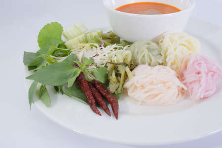rice noodles rainbow in fish curry sauce with vegetables on white backgroundの写真素材