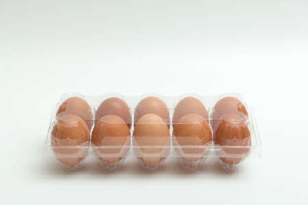 fresh eggs in plastic package on white backgroundの写真素材