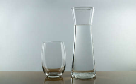 empty glass and pitcher of waterの写真素材