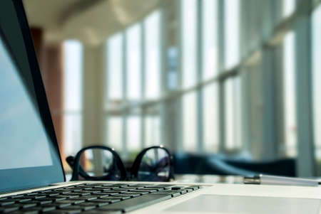 Laptop with smartphone, glasses, on the table in the lobbyの写真素材