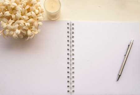 Flowers, notebooks on a white wooden table that looks relaxedの写真素材