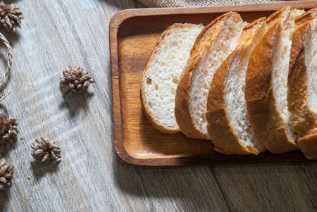 Baguette on a wooden tray placed on a wooden table to provide service from the top view.の写真素材