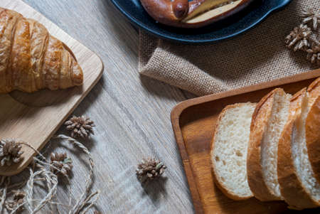 Baguette, croissants and pretzel on the wooden table from the top viewの写真素材