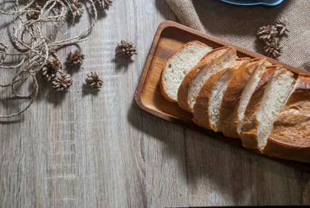 Baguette on a wooden tray placed on a wooden table to provide service from the top view.の写真素材