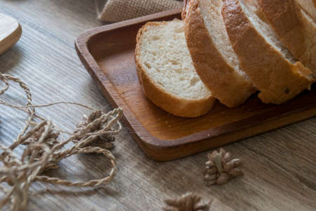 Baguette sliced ââon a wooden cutting board on a wooden table for customer service.の写真素材