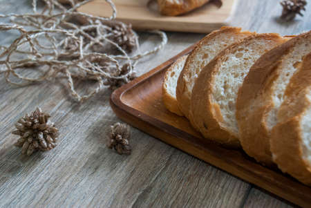 Baguette sliced ââon a wooden cutting board on a wooden table for customer service.の写真素材