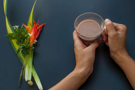 A cup of coffee in the hands of a woman who is about to drinkの写真素材
